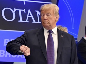 In this July 11, 2018 file photo, U.S. President Donald Trump checks the time at the Art and History Museum at the Park Cinquantenaire in Brussels.