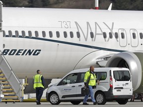 FILE - In this March 14, 2019, file photo, workers walk next to a Boeing 737 MAX 8 airplane parked at Boeing Field, in Seattle. A published report says pilots of an Ethiopian airliner that crashed followed Boeing's emergency steps for dealing with a sudden nose-down turn but couldn't regain control.