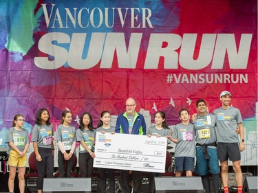 Vancouver Sun editor in chief Harold Munro presents a cheque to Brantford Eagles at the 35th annual Vancouver Sun Run in Vancouver on Sunday, April 14, 2019.