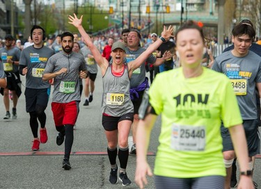 Megan Fretter of Surrey is delighted as she crosses the finish line at the 35th annual Vancouver Sun Run in Vancouver on Sunday, April 14, 2019.