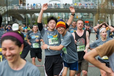 Buddies Oliver Zhou and Ted Byun, both of Port Moody, look relieved as they celebrate finishing The Vancouver Sun Run in Vancouver on Sunday, April 14, 2019.