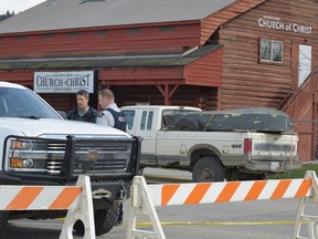 RCMP officers talk behind a barricade in front of the Salmon Arm Church of Christ in Salmon Arm, B.C. on Sunday, April 14, 2019. One person is in custody and one person was airlifted to hospital after a possible shooting in Salmon Arm, B.C. Salmon Arm RCMP say they are responding to a serious incident, which they say is a possible shooting, in the city, about 100 kilometres north of Kelowna.
