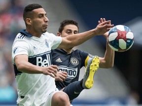 Vancouver Whitecaps' Ali Adnan, front left, and Philadelphia Union's Alejandro Bedoya, back, vie for the ball during the first half of an MLS soccer game in Vancouver, on Saturday April 27, 2019.
