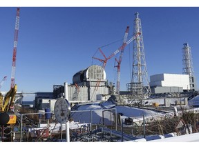 FILE - In this Jan. 25, 2018, file photo, an installation of a dome-shaped rooftop cover housing key equipment is near completion at Unit 3 reactor of the Fukushima Dai-ich nuclear power plant ahead of a fuel removal from its storage pool in Okuma, Fukushima Prefecture, northeast Japan. Japan has partially lifted an evacuation order in one of the two hometowns of the tsunami-wrecked Fukushima nuclear plant for the first time since the 2011 disaster. The action taken Wednesday, April 10, 2019, allows people to return about 40 percent of Okuma. The other hometown, Futaba, remains off-limits as are several other towns nearby.