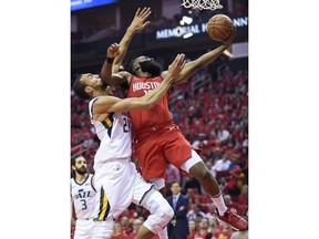 Houston Rockets guard James Harden, right, drives to the basket as Utah Jazz center Rudy Gobert defends during the first half of Game 1 of an NBA basketball first-round playoff series, Sunday, April 14, 2019, in Houston.