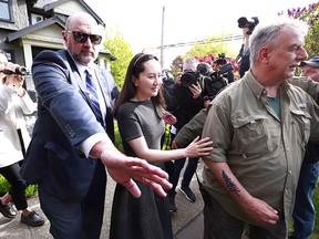 Huawei Technologies Chief Financial Officer Meng Wanzhou is escorted by security as she leaves her home on May 7, 2019 in Vancouver, Canada. Wanzhou is in court prior to extradition hearings and could face criminal charges of conspiracy and fraud in the U.S.