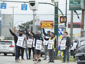Unionized port workers are seen outside the Port of Vancouver after being locked out in Vancouver, Thursday, May 30, 2019.