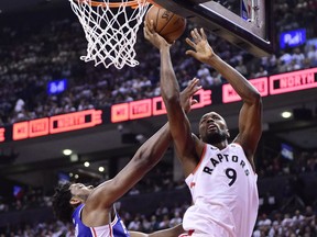 Toronto Raptors centre Serge Ibaka (9) scores over Philadelphia 76ers guard Jimmy Butler (23) during second half NBA playoff basketball action in Toronto on Tuesday, May 7, 2019.