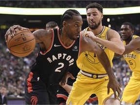 Toronto Raptors forward Kawhi Leonard (2) moves past Golden State Warriors guard Klay Thompson (11) during first half NBA basketball action in Toronto on Thursday Nov. 29, 2018.