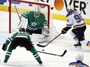Dallas Stars goaltender Anton Khudobin (35) defends against pressure from St. Louis Blues center Ryan O'Reilly (90) as Esa Lindell (23) helps on the play in the third period of Game 6 of an NHL second-round hockey playoff series in Dallas, Sunday, May 5, 2019.