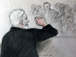 In this sketch by court artist Elizabeth Cook, Julian Assange salutes supporters at Southwark Crown Court in London on Wednesday May 1, 2019.