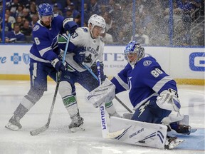 Andrei Vasilevskiy of the Tampa Bay Lightning makes a save against the Canucks' Bo Horvat last October as defenceman Anton Stralman tries to tie up the Vancouver forward. The Canucks won the game in Tampa, Fla.