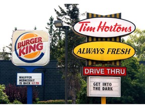 Burger King and Tim Hortons signs are displayed on St. Laurent Boulevard in Ottawa on Monday, August 25, 2014. Restaurant Brands International Inc. says it plans to grow to more than 40,000 restaurants around the world over the next eight to 10 years.