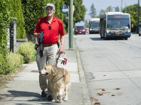 Bruce Gilmour, president of the Dunbar Residents’ Association, who is legally blind, on W41st with Marley. Currently parked cars provide a buffer zone between the sidewalk and the travel lanes. Photo: Gerry Kahrmann/Postmedia