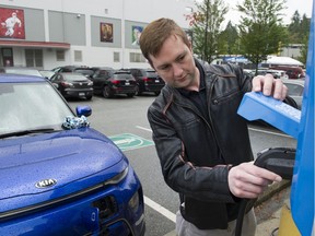 Byron Heslop replaces the charger from an EV station at Hillcrest Aquatic centre on Saturday after charging his 2020 Kai Soul EV in preparation for a trip to Whistler.
