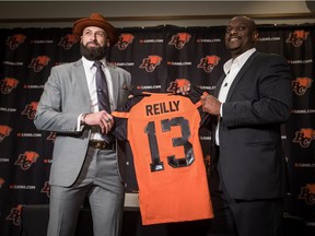 New B.C. Lions quarterback Mike Reilly, left, posed for a photograph with GM Ed Hervey during a news conference on Feb. 12, 2019 in Vancouver.