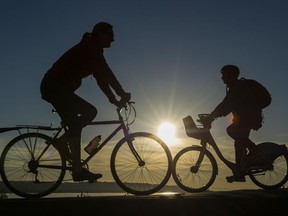 Cyclist ride along the seawall at English bay in the evening sun, Vancouver March 19 2019.