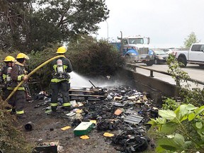 Vancouver firefighters battle a brush fire underneath the Oak Street Bridge.