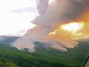 Thick smoke from wildfires burning in the region fills the air and blocks out the sun as vehicles travel on a rural road near Hwy 27 just after 5:30 p.m, between Fort St. James and Vanderhoof, B.C., on Wednesday August 22, 2018.