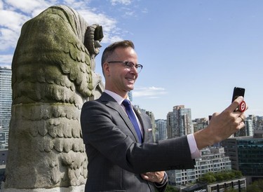 Concierge David Reid, born in the Year of the Ram, takes a selfie with the Ram Gargoyle on the roof of the Hotel Vancouver.