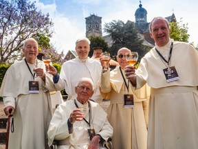The Grimbergen abbey monks pose with glasses of their historical beer in hand, as they celebrate the discovery of the 12th century secret.