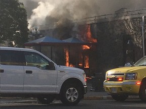 Flames shoot out of the front door of the former Monty's Showroom as firefighters battle a blaze in the derelict Plaza Hotel in downtown Victoria on Monday, May 6, 2019