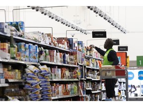 FILE - In this April 24, 2019, file photo a Walmart associate arranges items on a shelf at a Walmart Neighborhood Market in Levittown, N.Y. Walmart Inc. reports earnings on Thursday, May 16.