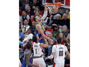Golden State Warriors center Andrew Bogut, top, dunks over Portland Trail Blazers guard Evan Turner during the first half of Game 4 of the NBA basketball playoffs Western Conference finals Monday, May 20, 2019, in Portland, Ore.