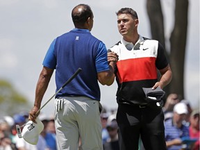 Brooks Koepka, right, shakes hands with Tiger Woods after finishing the first round of the PGA Championship golf tournament, Thursday, May 16, 2019, at Bethpage Black in Farmingdale, N.Y.