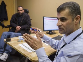 Settlement worker Sherwan Azad helps Syrian refugee Yousef Al Horani at the Immigrant Services Society Welcome Centre in Surrey on May 1. The centre has a range of offerings, from settlement and refugee-claimant services, to career programs, to family supports and counselling.