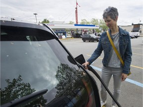 EV car owner Cheryl Griffin plugs her car into a BC Hydro Charging Station at the Canadian Superstore parking lot at Rupert Street and Grandview Highway in Vancouver.