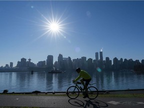 A cyclist makes his way around the seawall in Stanley Park while enjoying a sunny day in Vancouver.