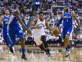 Kyle Lowry of the Toronto Raptors attempts to drive past Philadelphia 76ers' James Ennis III, left, and Mike Scott during Game 5 NBA playoff action at the Scotiabank Arena  in Toronto on Tuesday, May 7.