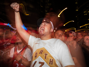 Fans celebrate in "Jurassic Park" outside the Scotiabank Arena during the last minutes of their team’s NBA finals debut against the Golden State Warriors, before winning 118-109, on May 30, 2019.