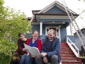 In front of her heritage home that will be undergoing renovations Janet Féirín, centre, with her son Kristoffer Knutson and his wife, Mandy Knutson, look over the plans for an infill home that will be built at the back of the property.