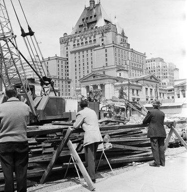 May 23, 1965: Passerby watches construction workers tear down buildings on the southeast corner of Robson and Howe in 1965. The building on the left is Danceland, a popular dance hall for many years. The Hotel Vancouver is in the background.