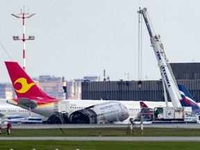 A crane works at the site of the damaged Sukhoi SSJ100 aircraft of Aeroflot Airlines in Sheremetyevo airport, outside Moscow, Russia, Monday, May 6, 2019. A Russian airliner burst into flames while making an emergency landing at Moscow's Sheremetyevo airport Sunday evening, and at least 41 people died, officials said.