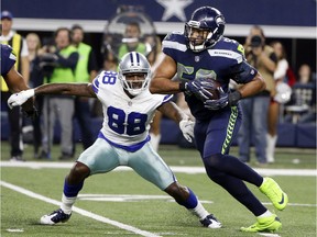 In this 2017 file photo, Dallas Cowboys wide receiver Dez Bryant is picked off by Seahawks linebacker K.J. Wright, who is returning to Seattle this season after injury troubles in 2018.