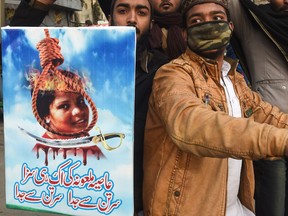 In this file photo taken on February 1, 2019 Pakistani Islamists hold a poster displaying an image of Asia Bibi, a Christian Pakistani woman accused of blasphemy, with a noose and a knife, during a protest against the Supreme Court decision on Bibi's case in Lahore.