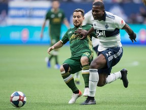 Doneil Henry of the Vancouver Whitecaps, right, battles Portland Timbers' Sebastian Blanco for the ball during Friday's MLS action at B.C. Place Stadium in Vancouver.