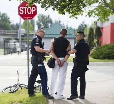 Transit Police Sgt. Clint Hampton (left) and Const. Darren Chua arrest a man for possession for the purpose of trafficking after observing a hand-to-hand exchange near City Parkway.