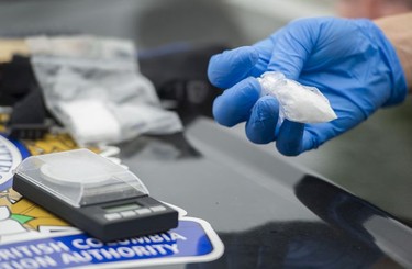 A Transit Police officer looks over drugs seized from a man arrested for possession for the purpose of trafficking near City Parkway.