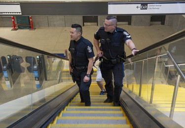 Transit Police Sgt. Clint Hampton and Const. Darren Chua ride the escalators to the platform at the Surrey Central Skytrain station.
