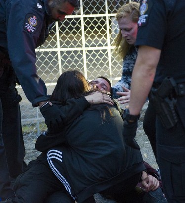 Friends and family comfort a man after he fell from a fence into his head. Transit Police check the individual after a report he was in possession of many knives. The man tried to climb over a fence and fell after getting hung up on the fence.