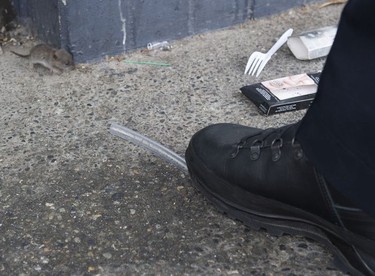 A rat pup moves past drug paraphernalia surrounding Transit Police Sgt. Clint Hampton's boot.