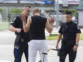 Sgt. Clint Hampton (left) and Const. Darren Chua stop a man suspected of drug trafficking near City Parkway in Surrey.