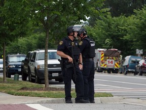 Virginia Beach Police Officers huddle near the intersection of Princess Anne Road and Nimmo Parkway following a shooting at the Virginia Beach Municipal Center on Friday, May 31, 2019 in Virginia Beach, Va,