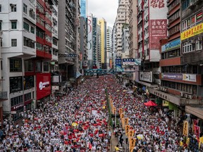 Protesters march on a street during a rally against China’s extradition law proposal on Sunday, June 9, 2019 in Hong Kong.