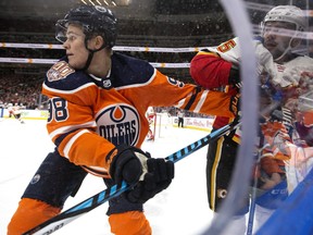 The Edmonton Oilers' Jesse Puljujarvi (98) checks the Calgary Flames Mark Giordano (5) during first period NHL action at Rogers Place, in Edmonton Saturday Jan. 19, 2019.