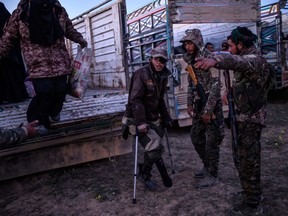 A man using crutches suspected of belonging to ISIL waits to be searched by members of the Kurdish-led Syrian Democratic Forces (SDF) just after leaving ISIL's last holdout of Baghouz, in the eastern Syrian province of Deir Ezzor on March 4, 2019.